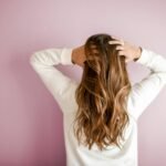 Femme de dos, les mains dans ses cheveux longs